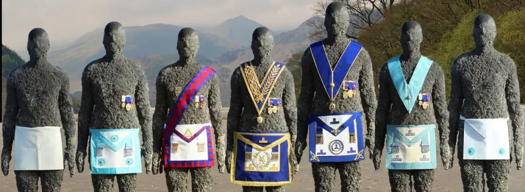 Image of three statues wearing masonic regalia